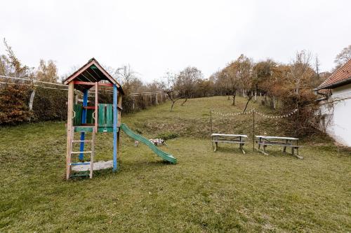 a playground with a slide in a field at Taurus Vendégház in Óbánya