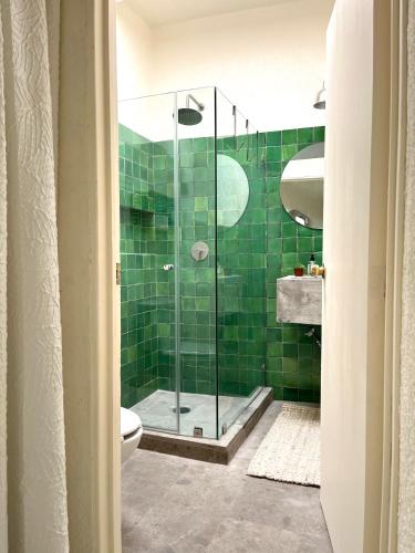 a bathroom with a shower with green tiles at Artisanal Loft Coyoacan in Mexico City