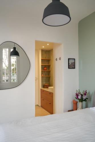 a bedroom with a white bed and a mirror at Le Petit Croquant in Marseille