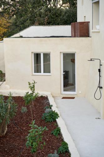 a white house with a walkway in front of a yard at Le Petit Croquant in Marseille
