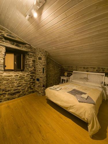 a bedroom with a large bed in a stone wall at BIDEARTEAN, Caserío vasco, Recién reformado in Záitegui