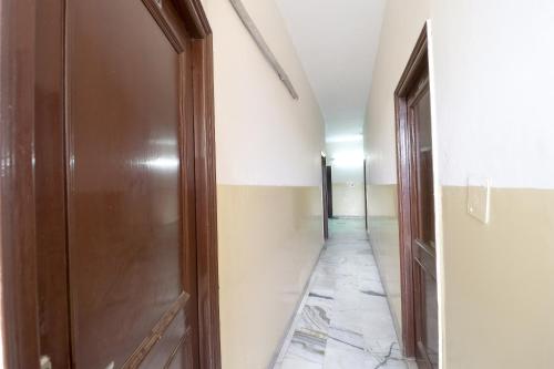 a hallway with a wooden door and a hallway with a tile floor at SPOT ON Motel Haryana in Chandīgarh