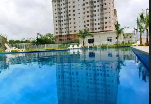 a large swimming pool in front of a tall building at Apto Araçagy Ilha de São Luis in São-José-do-Ribamar