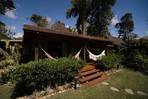 a small building with a porch with a hammock at Villa Cozy in Arraial d'Ajuda