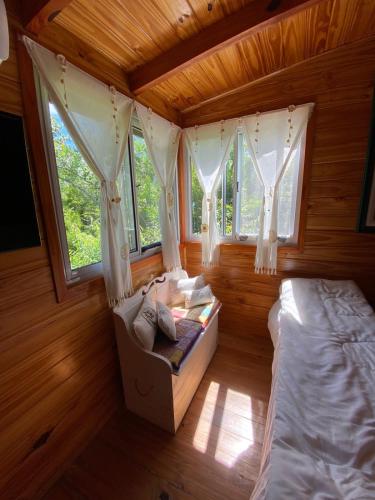 a bedroom with two beds and windows in a cabin at Cabaña La Paz in Tigre