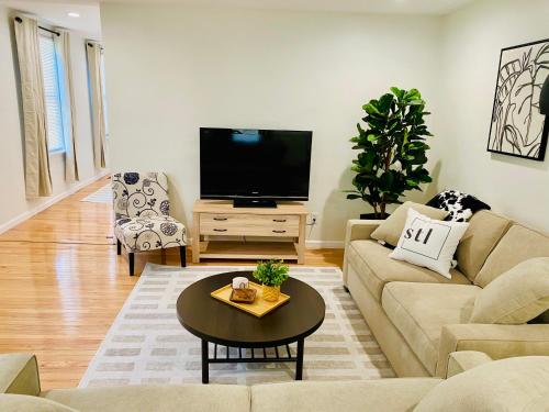a living room with a couch and a flat screen tv at Family Favorite Heart of The Hill in Saint Louis