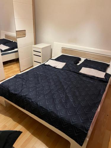 a bedroom with a bed with a black comforter at Motel Schwanen in Schlattingen