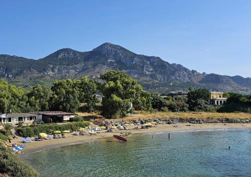 a beach with umbrellas and people on the beach at Lapta Residential Complex IRINA in Lapithos