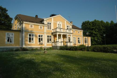 a large house with a large lawn in front of it at Spånhults Herrgård Hotel in Norrahammar