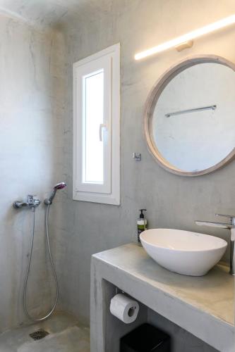 a bathroom with a white sink and a mirror at Mykonos Residence Villas & Suites Merchia beach in Merchia Beach