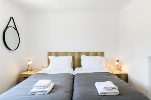 a bedroom with two beds with towels on them at Mykonos Residence Villas & Suites Merchia beach in Merchia Beach