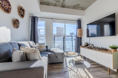 a living room with a couch and a large window at L'Horizon Urbain, Centre Ville, Toit-Terrasse Gym in Quebec City