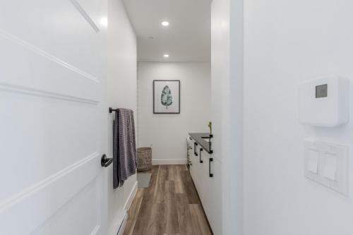 einen Flur eines Hauses mit weißen Wänden und Holzböden in der Unterkunft L'Horizon Urbain, Centre Ville, Toit-Terrasse Gym in Québec