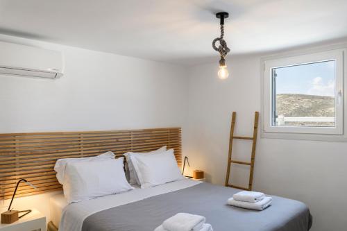 a bedroom with a bed with two towels on it at Mykonos Residence Villas & Suites Merchia beach in Merchia Beach