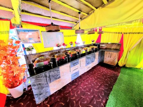 a restaurant with a yellow and red kitchen with a bar at Ali jan hotel in Srinagar