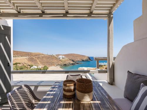 a table on a balcony with a view of the ocean at Mykonos Residence Villas & Suites Merchia beach in Merchia Beach