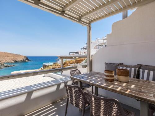 a table on a balcony with a view of the ocean at Mykonos Residence Villas & Suites Merchia beach in Merchia Beach