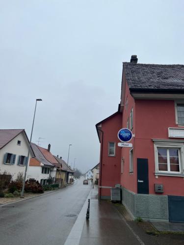 a street in a town with a red building at Motel Schwanen in Schlattingen