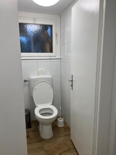 a bathroom with a white toilet and a window at Motel Schwanen in Schlattingen
