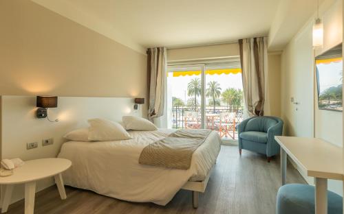 a hotel room with a bed and a window at La Dolce Vita Hotel in Menton
