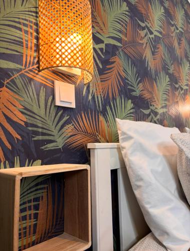 - une chambre avec un mur recouvert de papier peint en feuilles de palmier dans l'établissement Cosy Home Next To Disneyland & Train, à Torcy