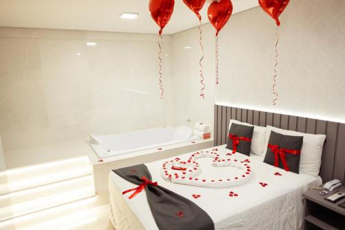 a bedroom with a cake on a bed with red hearts at Paris Hotel by H Hotéis - Business in Taguatinga