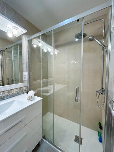 a bathroom with a glass shower with a sink at Apartment Sagrera in Barcelona