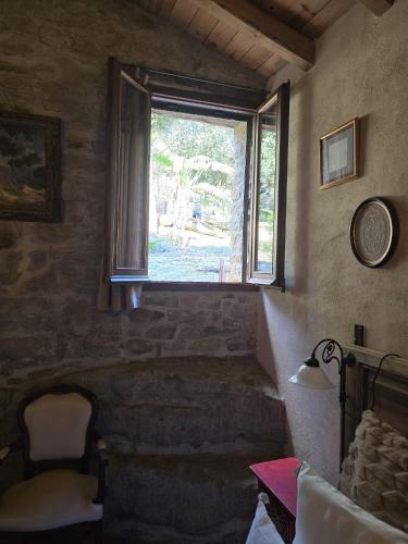 a bedroom with a window and a chair in a room at El Racó dels Mussols 2 in Adri