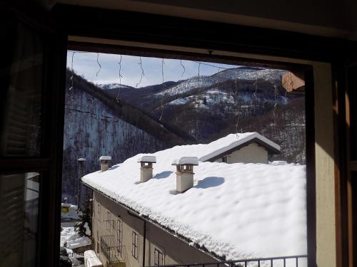 a view of a snow covered roof from a window at B&B Locanda Del Mulino in Pamparato