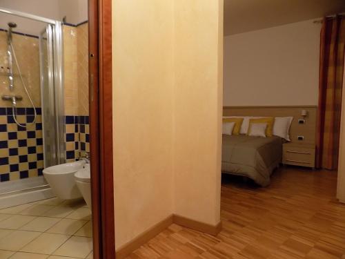 a bathroom with a bed and a bathroom with a shower at B&B Locanda Del Mulino in Pamparato