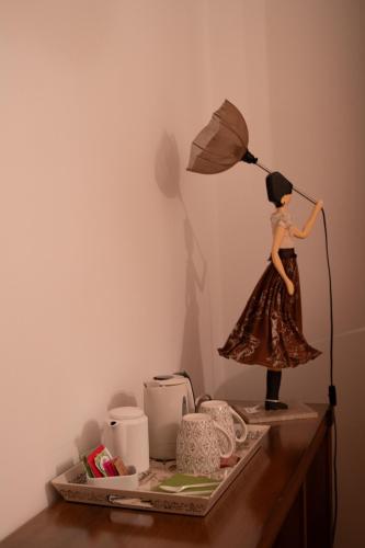 a figurine of a woman holding an umbrella on a table at Arca Hotel in Pienza