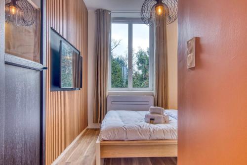 - une petite chambre avec un ours en peluche assis sur un lit dans l'établissement L'Oasis - Bel appart climatisé quartier point du jour Lyon 5, à Lyon