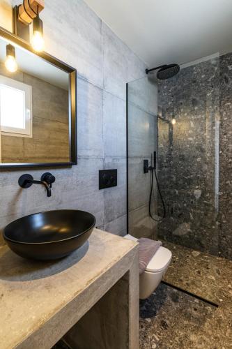 a bathroom with a sink and a shower at Mykonos Residence Villas & Suites Merchia beach in Merchia Beach