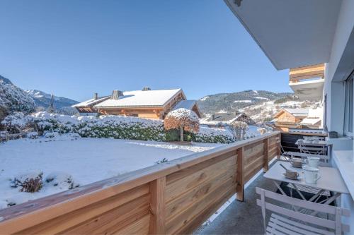 un balcon enneigé avec vue sur une maison dans l'établissement Appartement Hermine - Welkeys, à Megève