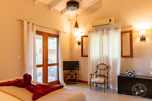 a bedroom with a bed and a tv and a window at Casa Mapache in Tamarindo