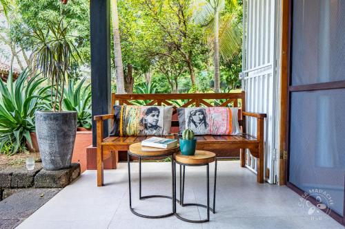 a porch with a bench and a table on a porch at Casa Mapache in Tamarindo