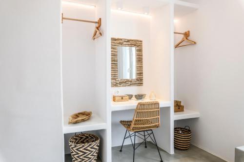 a room with a chair and a mirror at Mykonos Residence Villas & Suites Merchia beach in Merchia Beach