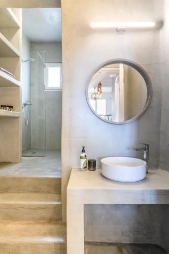 a bathroom with a sink and a mirror at Mykonos Residence Villas & Suites Merchia beach in Merchia Beach