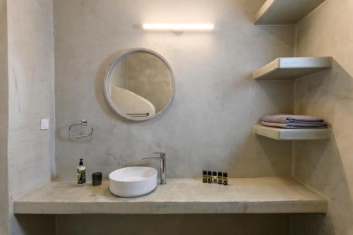 a bathroom with a sink and a mirror at Mykonos Residence Villas & Suites Merchia beach in Merchia Beach