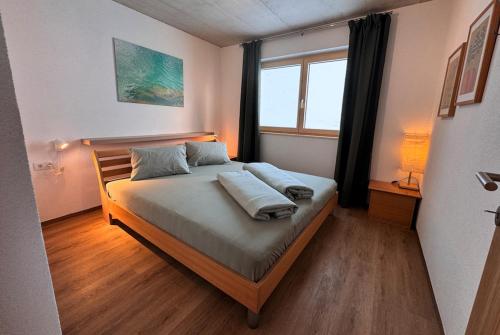 a bedroom with a bed and a window at Bungalow Laroo in Ried im Oberinntal
