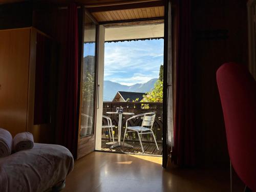 - une chambre dotée d'une porte s'ouvrant sur un balcon avec une table et des chaises dans l'établissement Les Tilleuls, à Le Biot