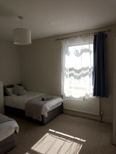 a bedroom with two beds and a window at Double or twin room in town centre in East Grinstead