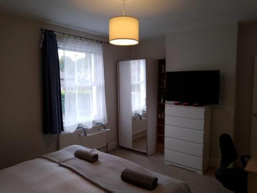 a bedroom with a bed and a flat screen tv at Double or twin room in town centre in East Grinstead