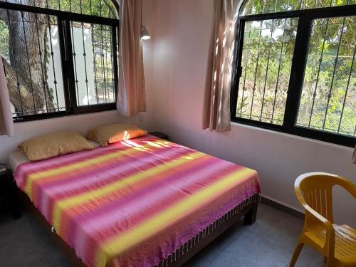 a bedroom with a bed with a colorful blanket on it at Casa Barbara in Lo de Marcos