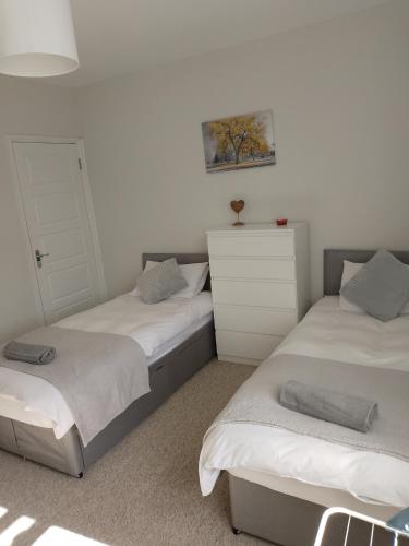a bedroom with two beds and a dresser in it at Double or twin room in town centre in East Grinstead