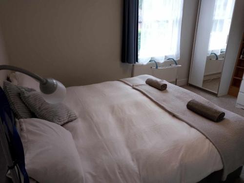 a white bed with two pillows and a lamp on it at Double or twin room in town centre in East Grinstead