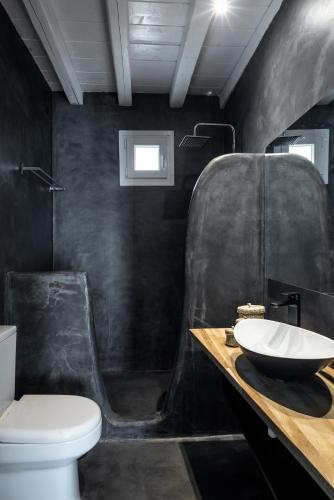 a black bathroom with a sink and a toilet at Mykonos Residence Villas & Suites Merchia beach in Merchia Beach