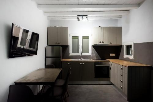 a kitchen with a table and a sink and a refrigerator at Mykonos Residence Villas & Suites Merchia beach in Merchia Beach