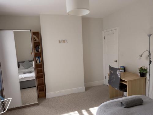 a bedroom with a desk and a bed and a mirror at Double or twin room in town centre in East Grinstead