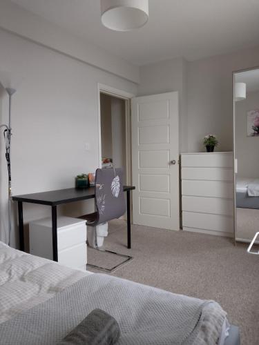 a bedroom with a desk and a bedroom with a bed at Double or twin room in town centre in East Grinstead